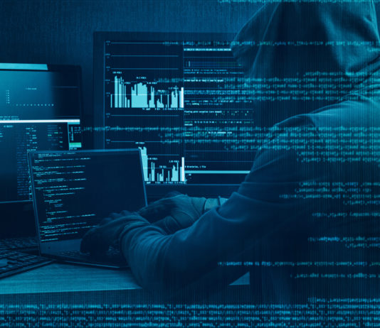 Hacker vor mehreren Bildschirmen